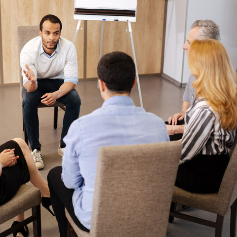 group session of five participants with group leader speaking