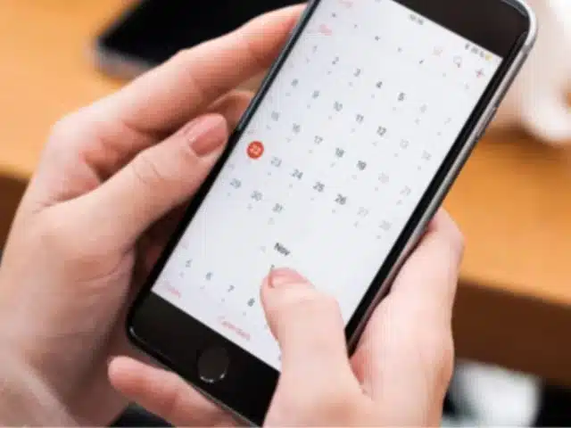 mobile device in hand displaying online calendar